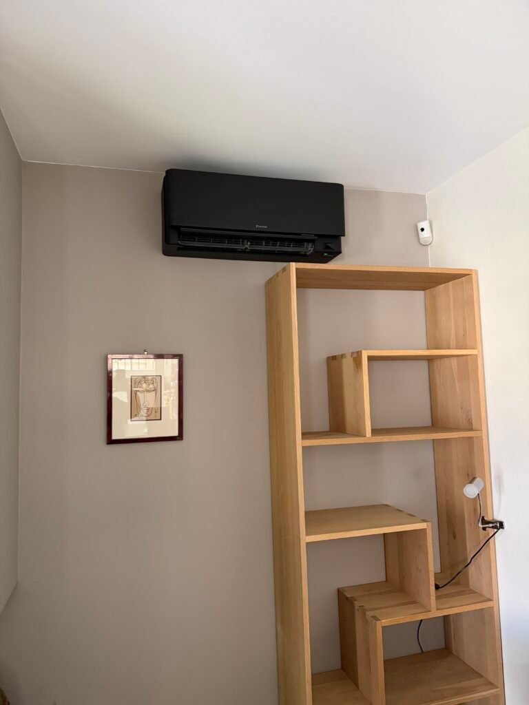 Climatisation murale noire mate installée dans un intérieur